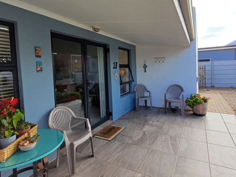 A well-maintained covered patio area featuring tiled flooring and modern sliding glass doors, providing a pleasant outdoor transition space.
