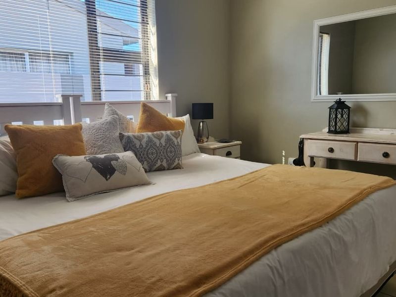 A well-maintained bedroom featuring tiled flooring and venetian blinds, offering a comfortable and functional living space.