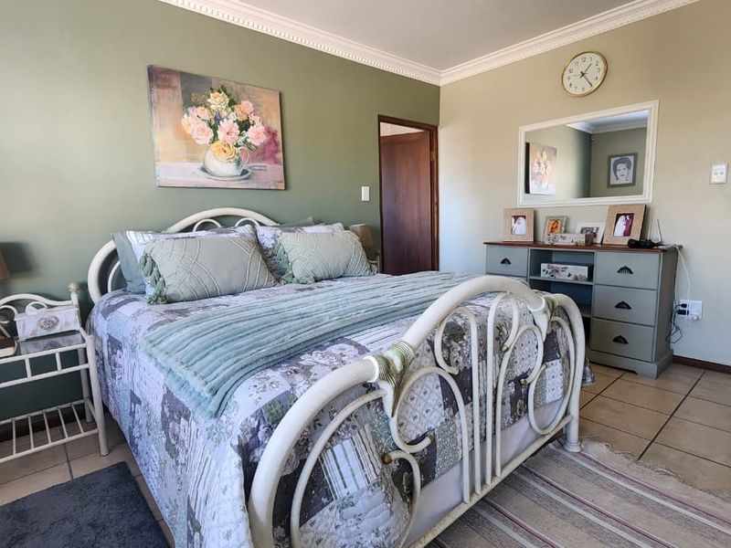 A well-lit bedroom featuring tiled flooring and decorative crown molding, providing a neutral base for personalization.