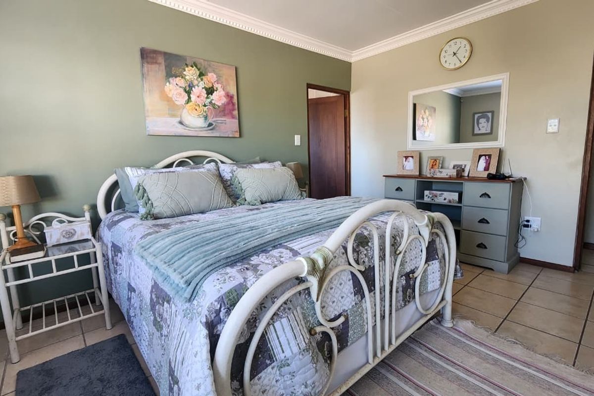 A well-lit bedroom featuring tiled flooring and decorative crown molding, providing a neutral base for personalization.