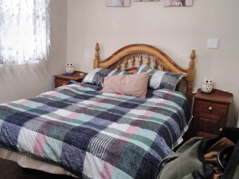 A standard bedroom featuring neutral wall finishes and a window with curtains.