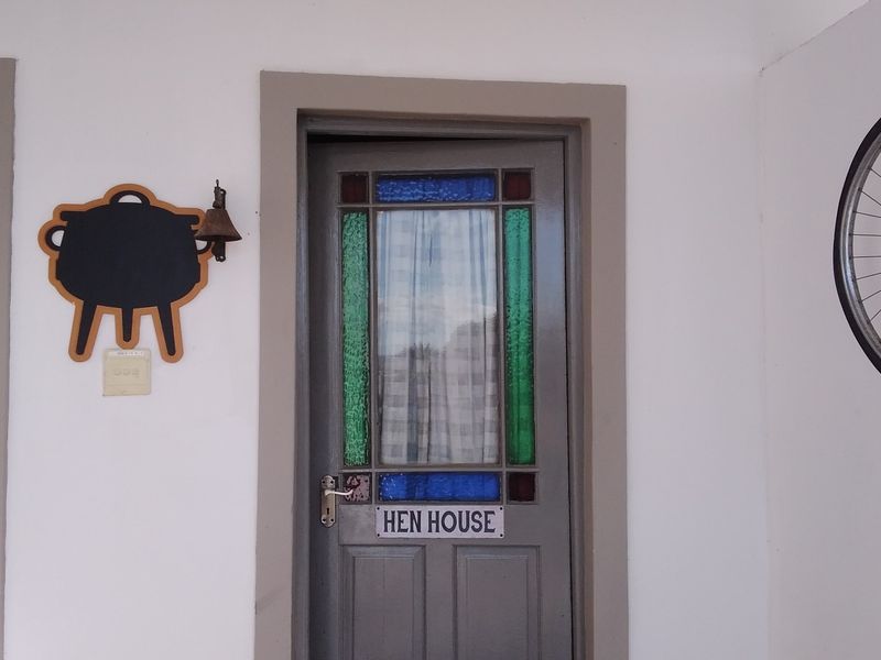 Entrance area featuring a grey door with decorative stained glass panels and a classic door bell.