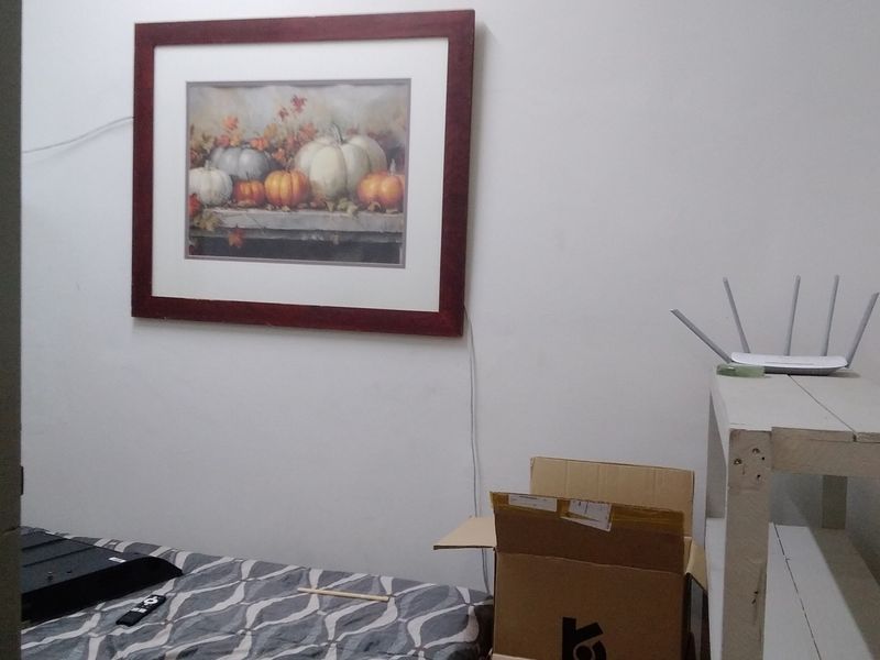A simple bedroom space with plain walls, suitable for use as a guest room or home office.