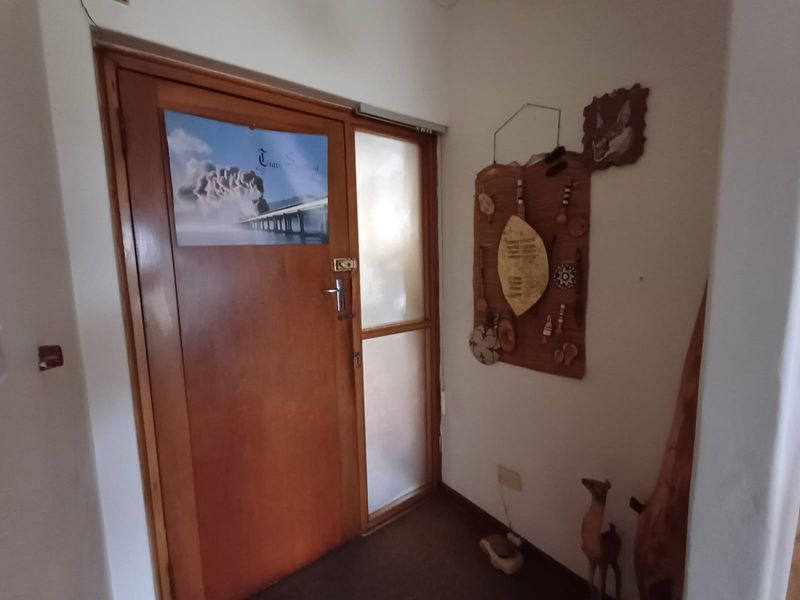An entrance area featuring a solid timber front door with a frosted glass sidelight, providing a functional and private entry point to the home.