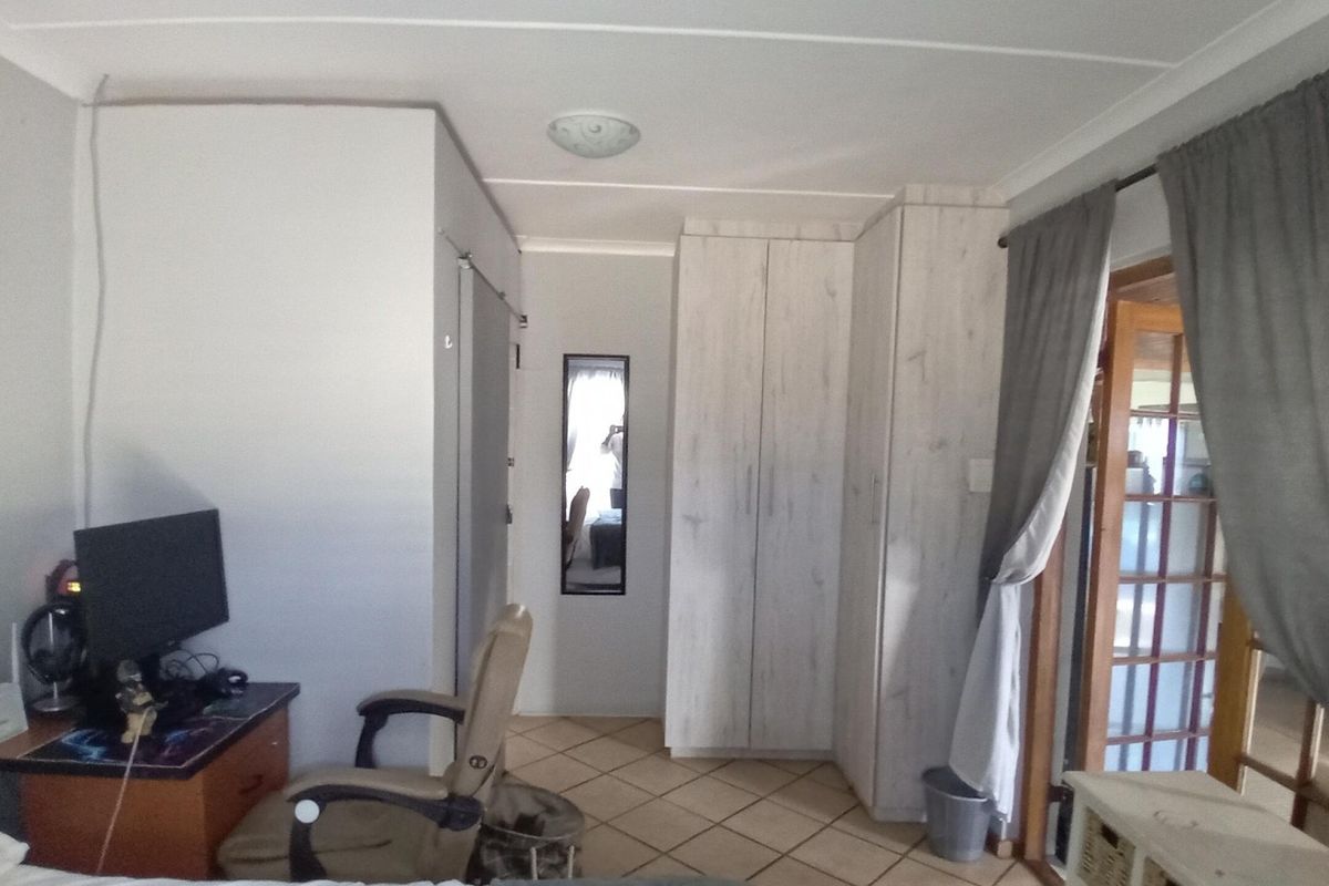 Bedroom featuring built-in cupboards, tiled flooring, and a sliding door providing access to an adjacent space.