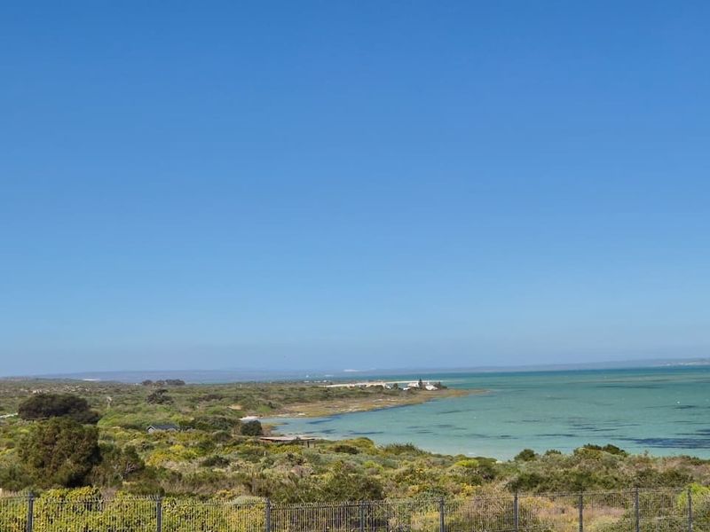 A scenic elevated view overlooking the coastal landscape, natural vegetation, and the turquoise waters of the lagoon.