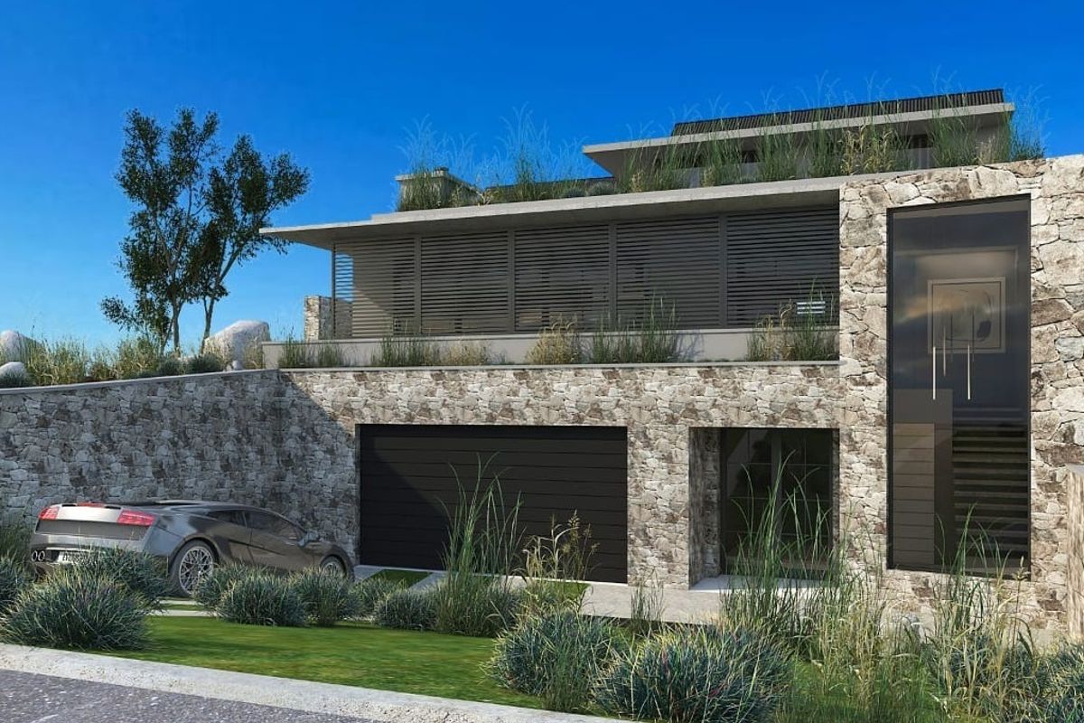 Modern architectural residence featuring natural stone cladding, integrated garage, and contemporary louvred facade elements set within a landscaped environment.