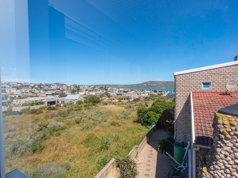 Elevated view overlooking the surrounding neighbourhood and distant coastline, captured from an interior window.
