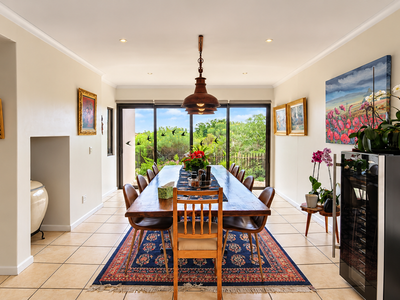 Spacious dining room featuring ceramic tiled flooring, recessed lighting, and large sliding glass doors that provide natural light and access to the garden.