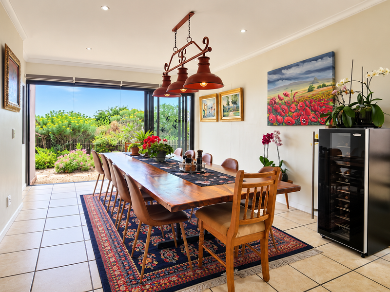 Spacious dining room featuring tiled flooring, recessed lighting, and large sliding glass doors that open to a landscaped garden.