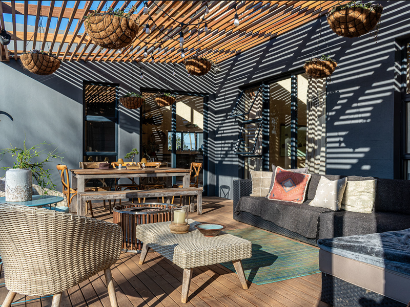 A spacious outdoor patio featuring timber decking and a slatted timber pergola, providing a stylish and functional area for outdoor living and entertaining.