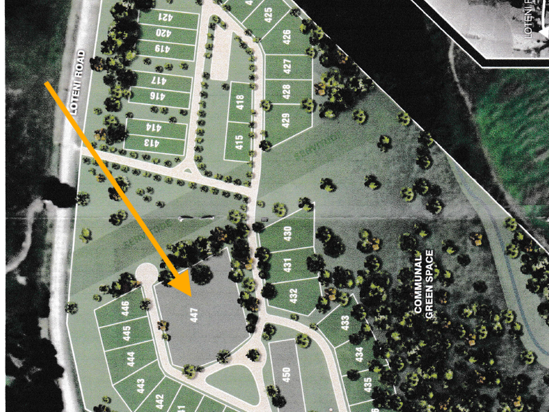 An aerial site plan showing the layout of subdivided residential plots, internal roads, and communal green space within the development.