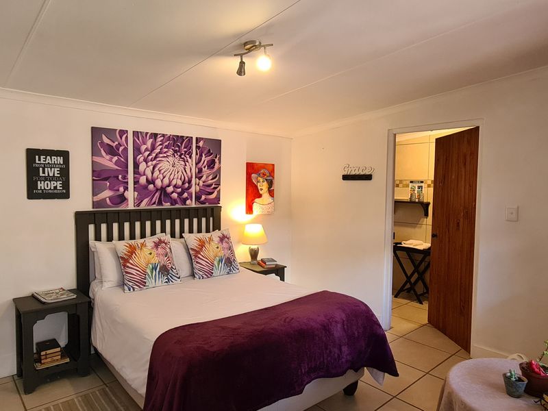 A bedroom featuring tiled flooring, built-in cabinetry, and an en-suite bathroom access.