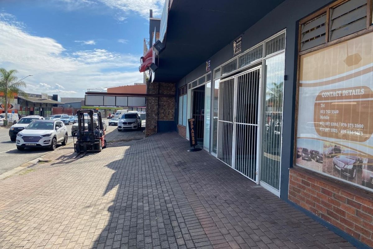 Commercial storefront featuring a paved sidewalk, brick facade, and secure glass entrance, suitable for retail or office use.