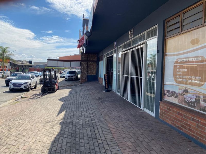 Commercial storefront featuring a paved sidewalk, brick facade, and secure glass entrance, suitable for retail or office use.