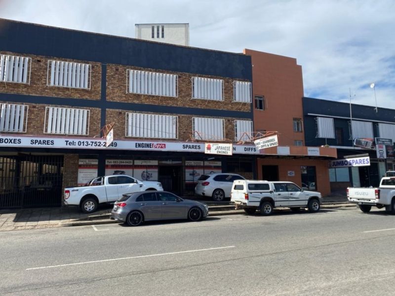 Commercial street-level storefront featuring brick facade, security shutters, and prominent signage, suitable for automotive parts or retail business operations.
