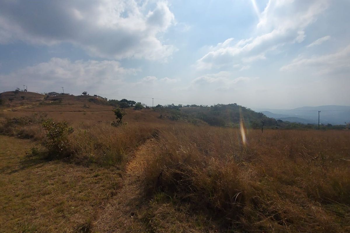 Expansive rural landscape view featuring rolling hills and open grassland on a farm property.