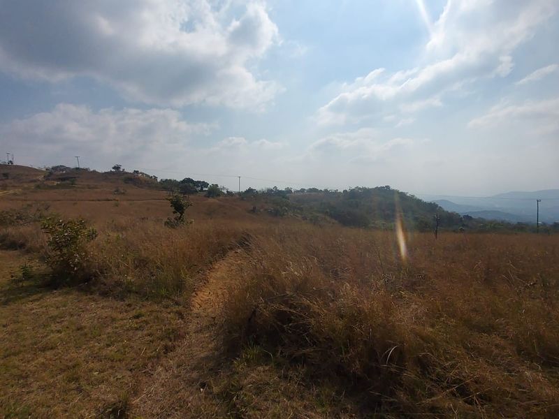 Expansive rural landscape view featuring rolling hills and open grassland on a farm property.
