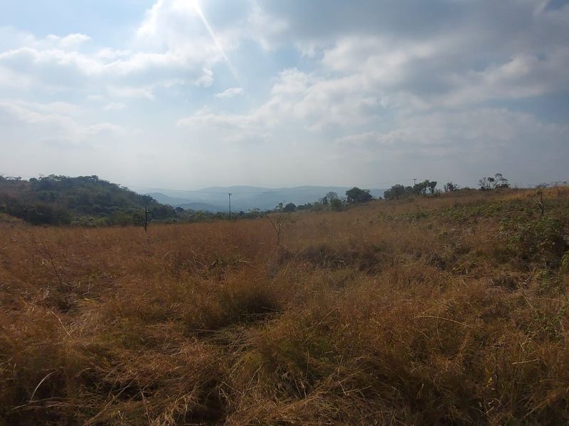 A wide-angle view of the expansive, undeveloped rural landscape and rolling hills surrounding the property.