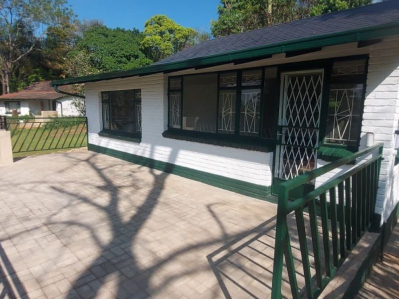 A spacious outdoor patio area featuring brick paving, a built-in braai, and secure metal railings, ideal for outdoor entertaining.