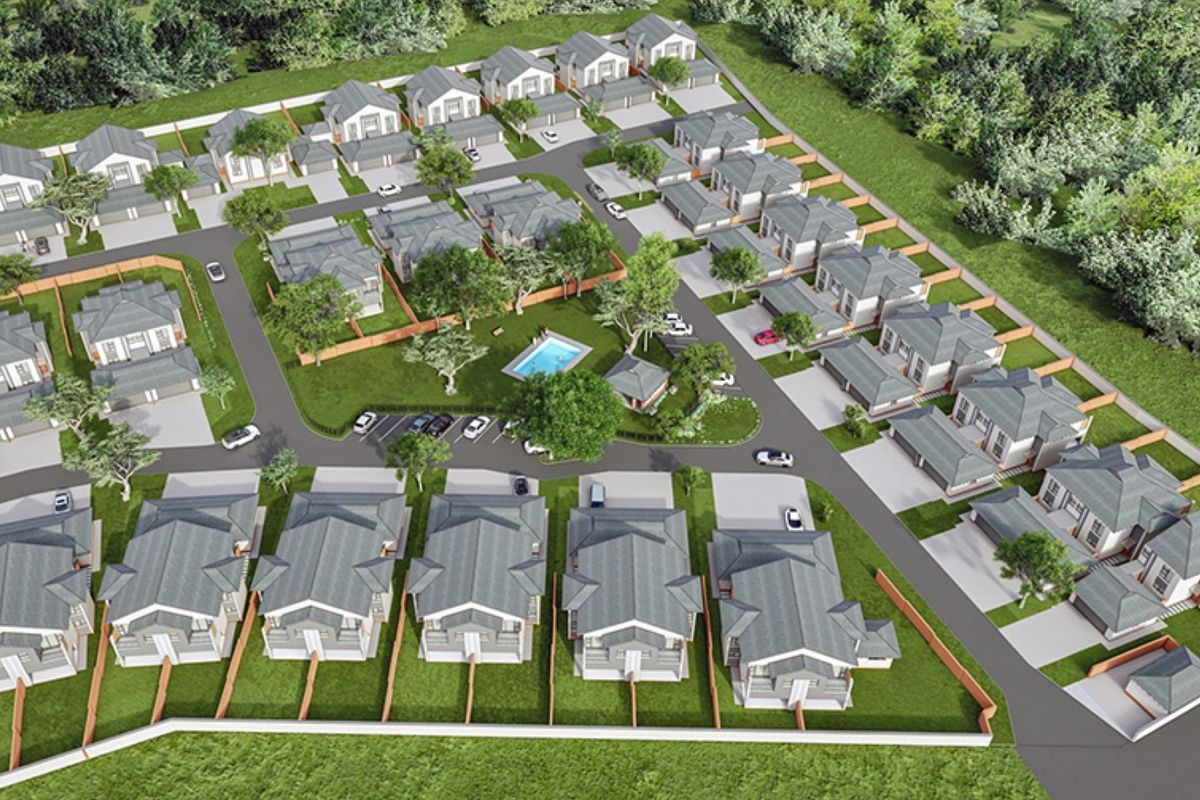 Aerial view of a residential townhouse complex featuring multiple units, paved driveways, communal swimming pool, and landscaped garden areas.