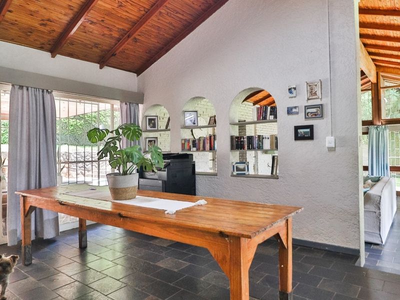 Spacious living area featuring a vaulted timber ceiling with exposed beams, slate tile flooring, and unique built-in arched wall niches.