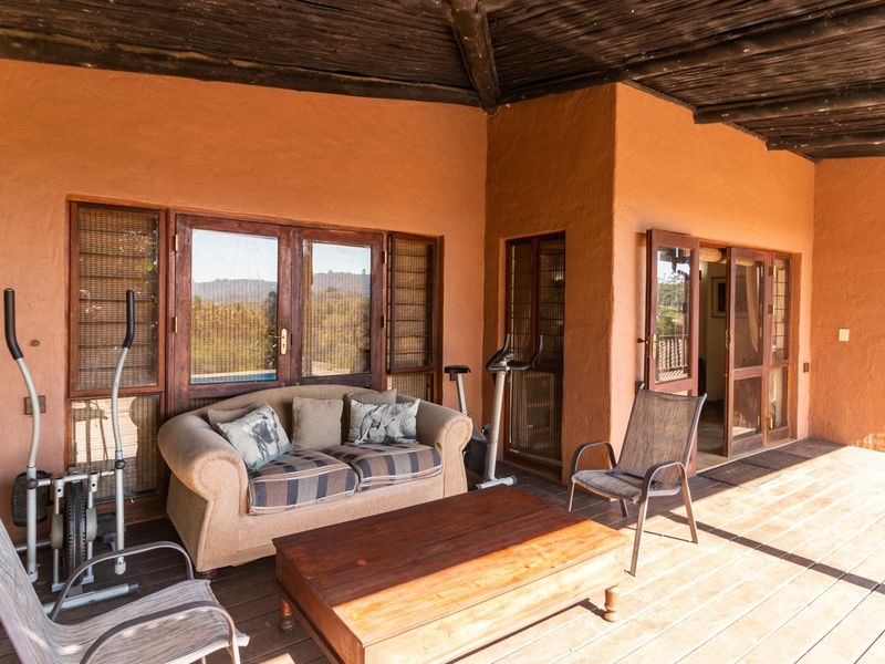 A spacious covered patio featuring timber decking and exposed beam ceilings, providing a comfortable outdoor living area with direct access to the home.