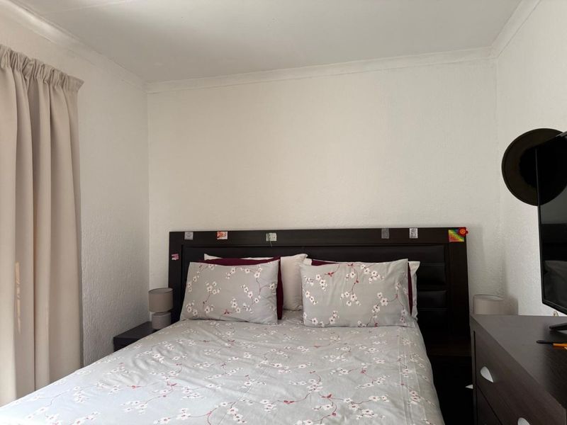 A standard bedroom featuring neutral wall finishes and a curtain rail, providing a functional and well-maintained sleeping space.