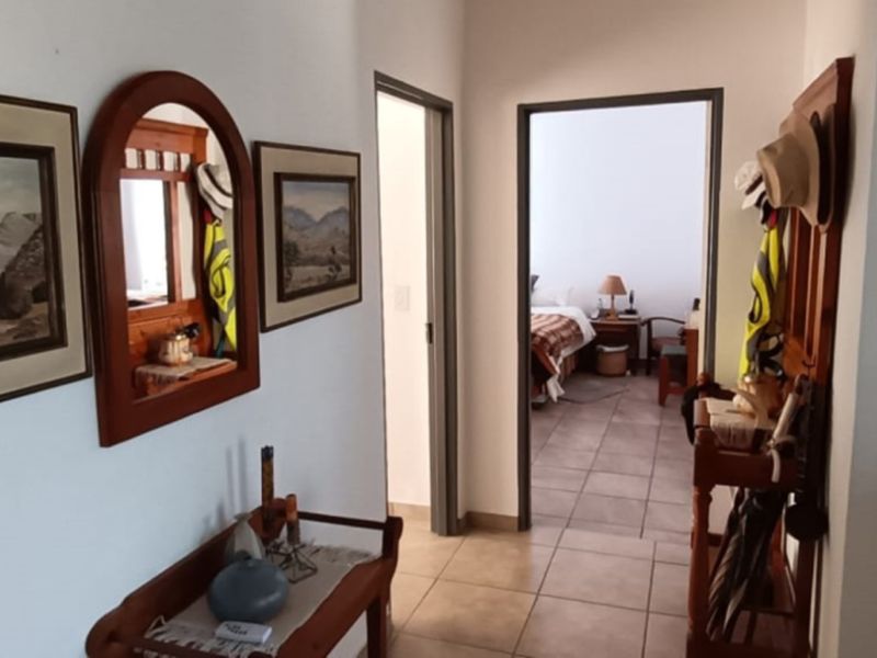 A functional hallway with tiled flooring providing access to adjacent rooms, featuring neutral wall finishes and standard door frames.