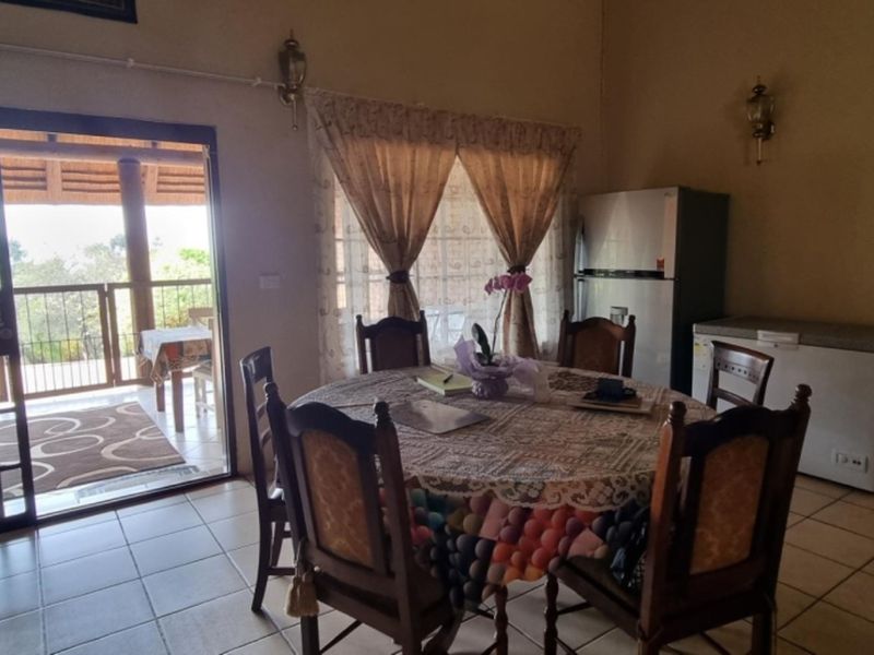 Open plan dining area featuring tiled flooring and direct access to a covered patio through sliding glass doors.