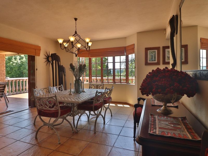 A dining room featuring tiled flooring, a bay window with natural light, and direct access to an outdoor balcony area.
