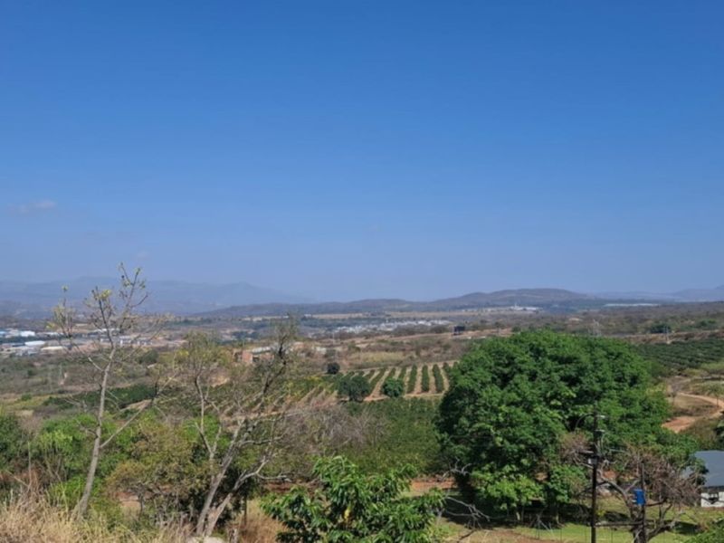 A wide-angle view of the surrounding landscape, featuring rolling hills, agricultural fields, and distant residential development.