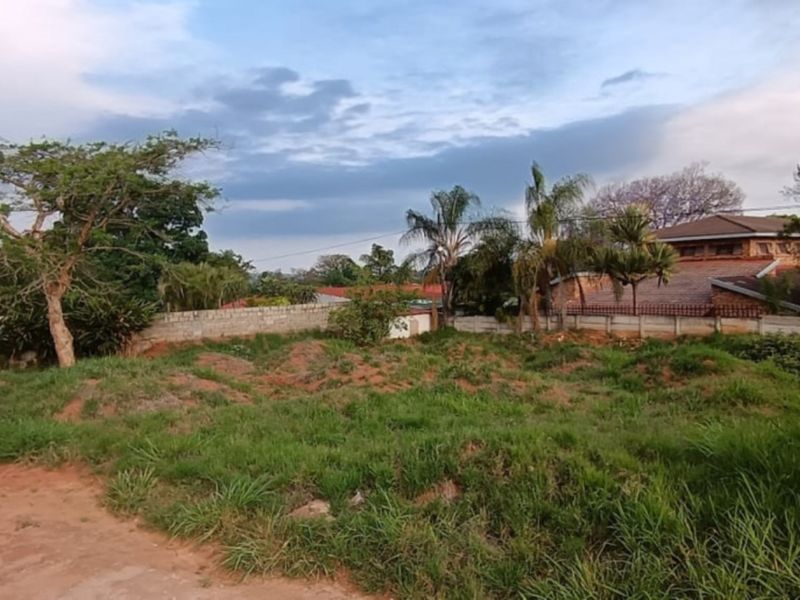 A vacant residential plot featuring established perimeter walls and electric fencing, offering a clear space ready for development.