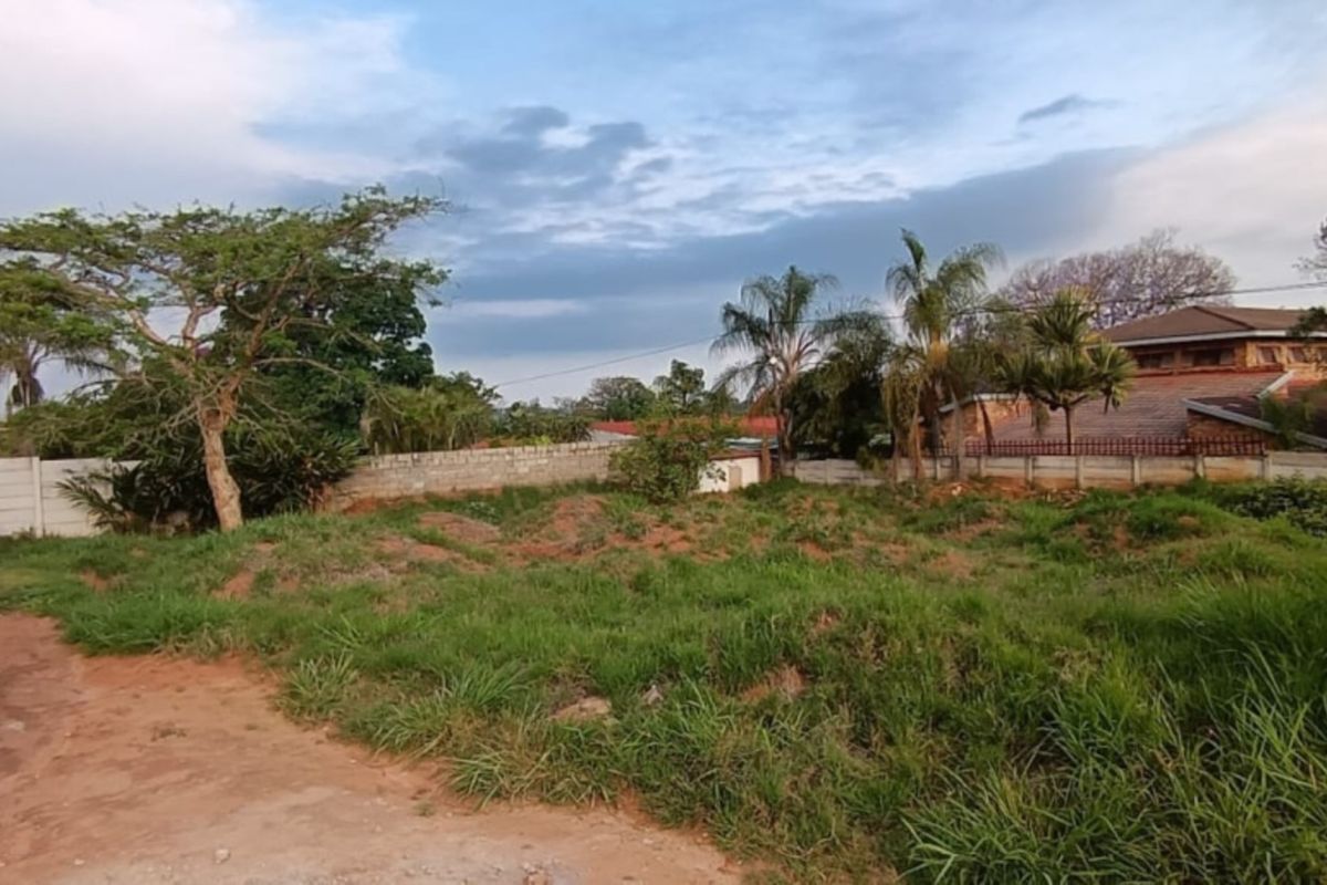 A vacant residential plot featuring perimeter boundary walls and existing electric fencing, offering a blank canvas for future development.