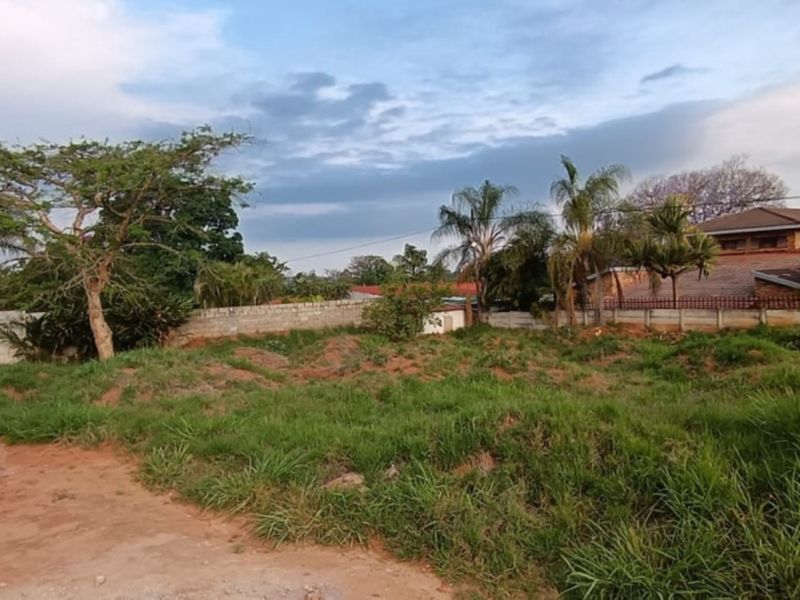 A vacant residential plot featuring perimeter boundary walls and existing electric fencing, offering a blank canvas for future development.