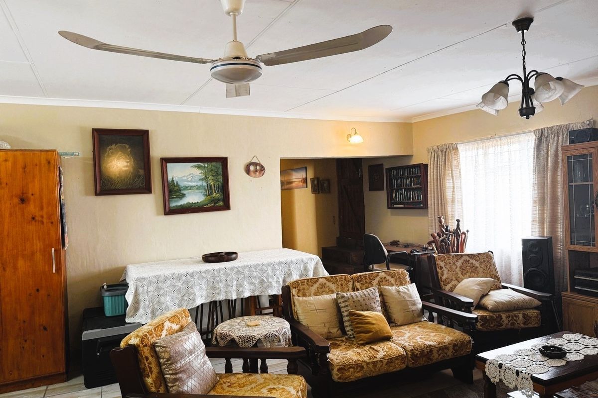 A spacious living room featuring tiled flooring, a ceiling fan, and neutral wall finishes, offering a comfortable and functional layout.