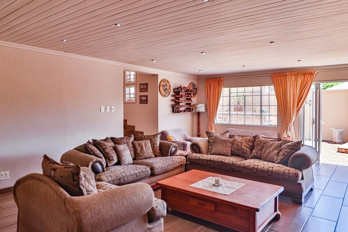 Spacious living room featuring timber-clad ceilings, recessed lighting, and large sliding doors providing direct access to the outdoor patio area.