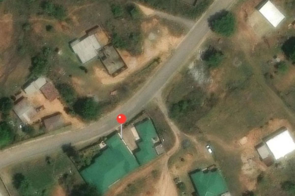 An aerial view of the property showing the building footprint, metal roof, and surrounding site layout.