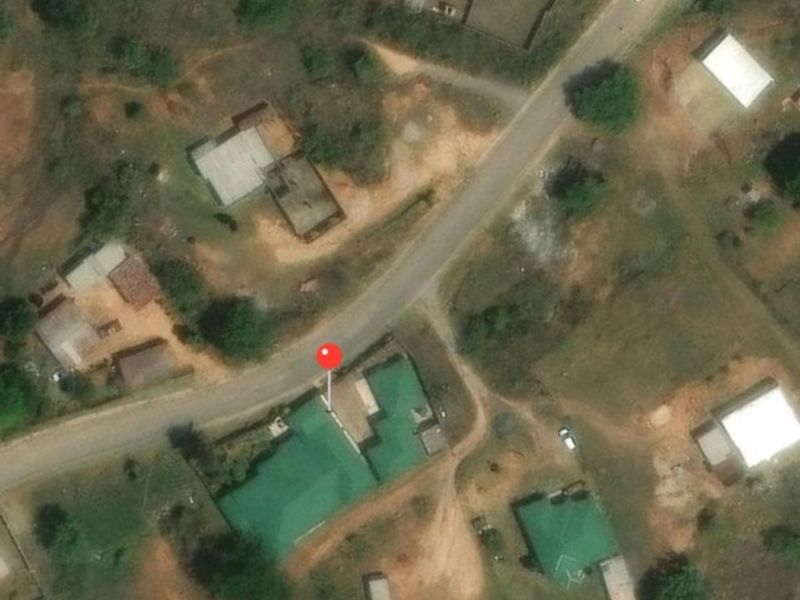 An aerial view of the property showing the building footprint, metal roof, and surrounding site layout.
