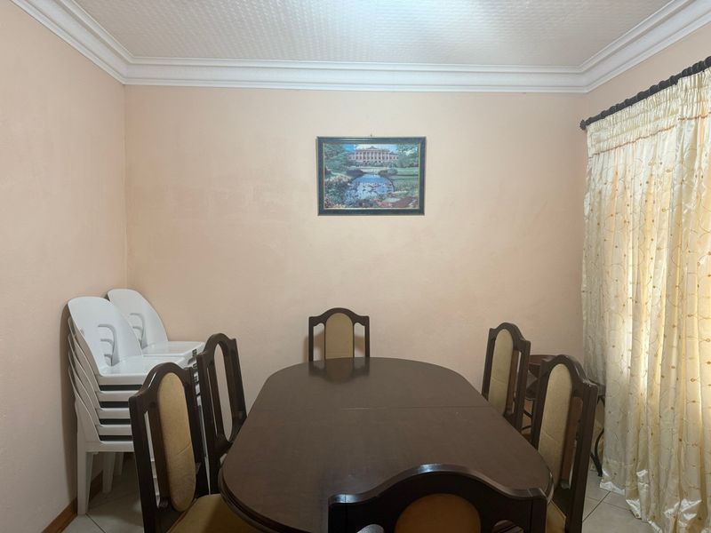 A functional dining room featuring crown molding and neutral wall finishes, providing a blank canvas for modern interior updates.