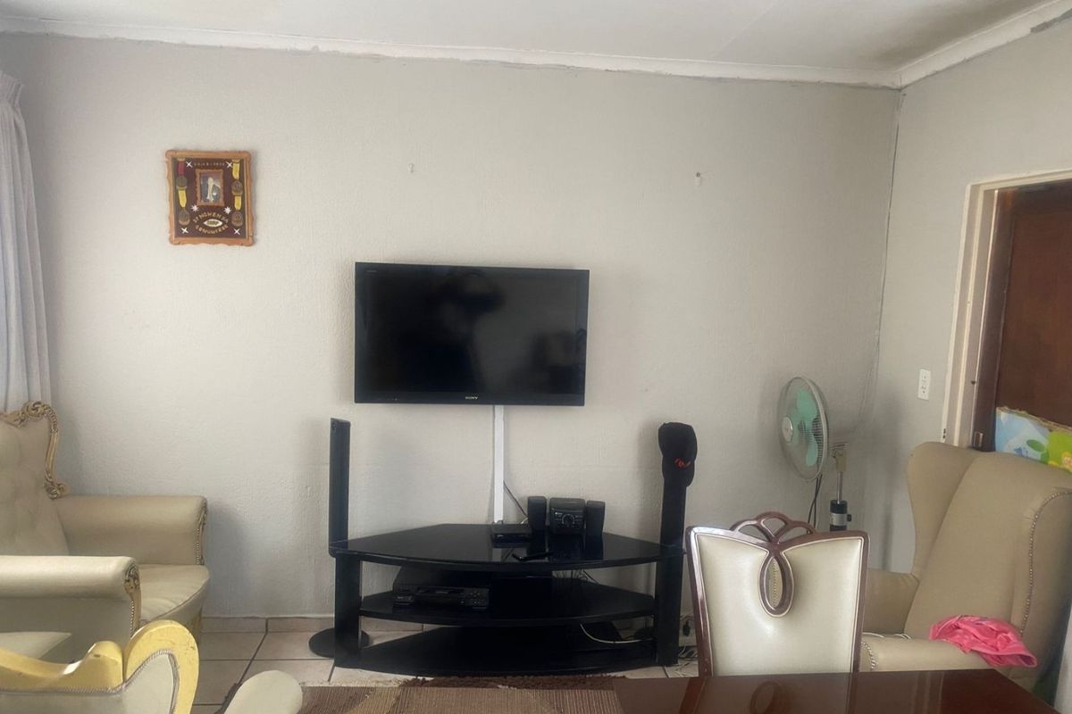 A living room area featuring tiled flooring and coved ceilings, providing a functional space for relaxation and entertainment.