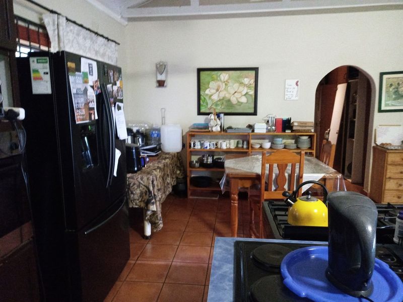 A functional kitchen area featuring tiled flooring and an arched doorway leading to adjacent living spaces.
