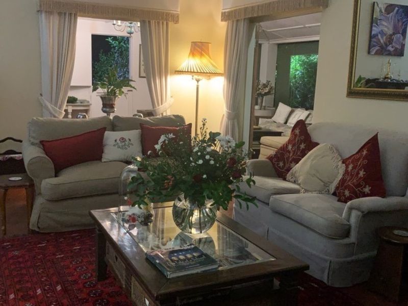 A cozy living room featuring traditional archway openings and decorative curtain pelmets, creating a warm and inviting atmosphere.