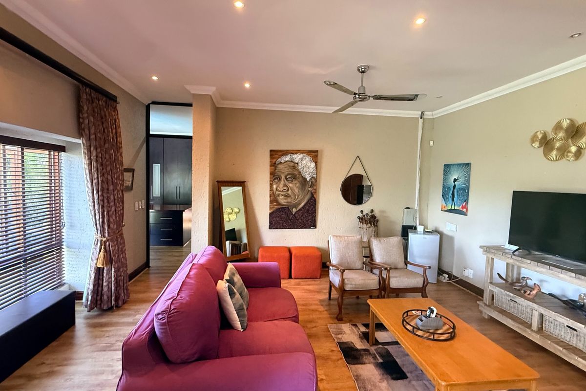 Spacious living room featuring laminate flooring, recessed downlights, a ceiling fan, and direct access to an outdoor area through sliding doors.