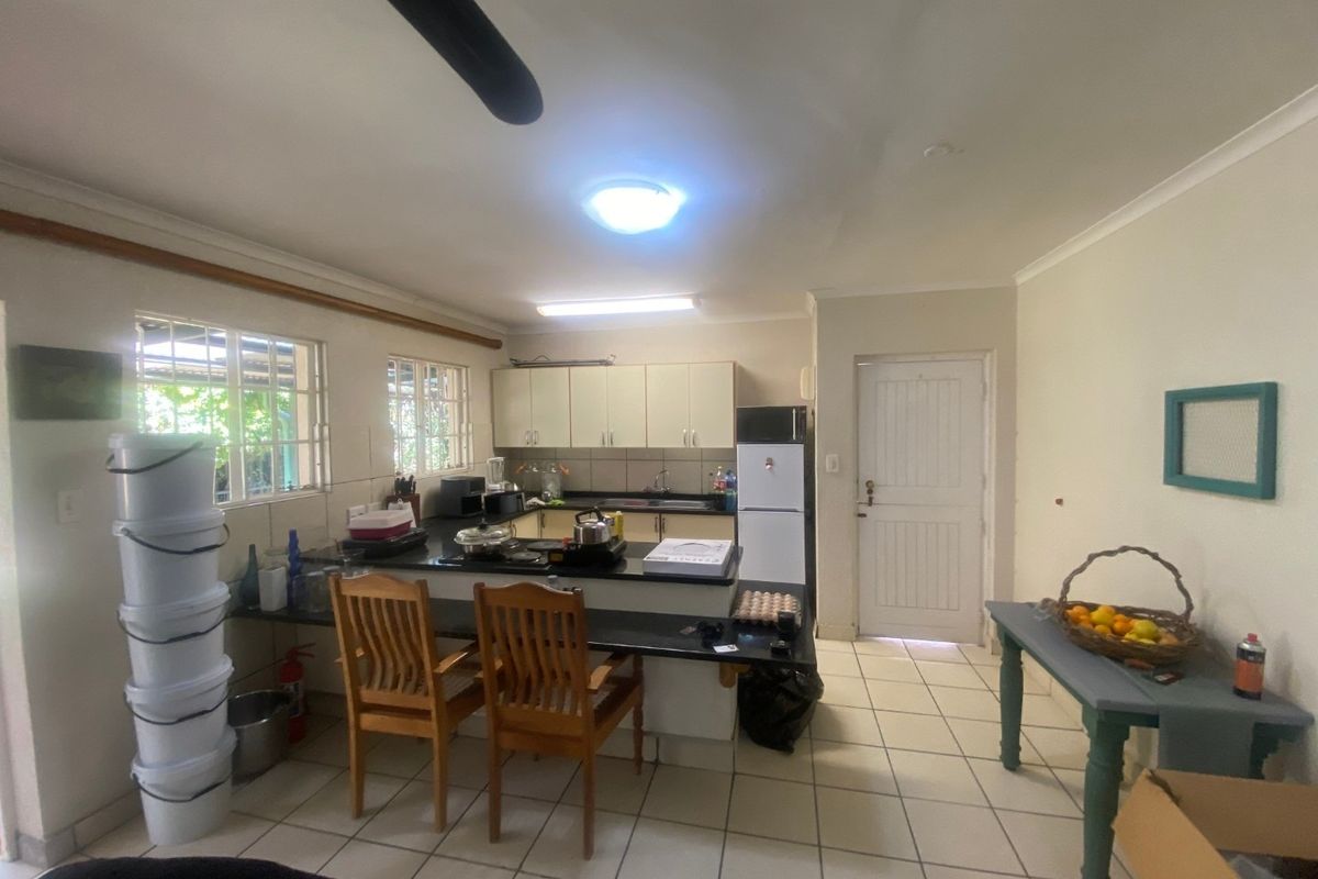 A functional kitchen featuring built-in cabinetry, granite countertops, and tiled flooring, with direct access to an exterior door.