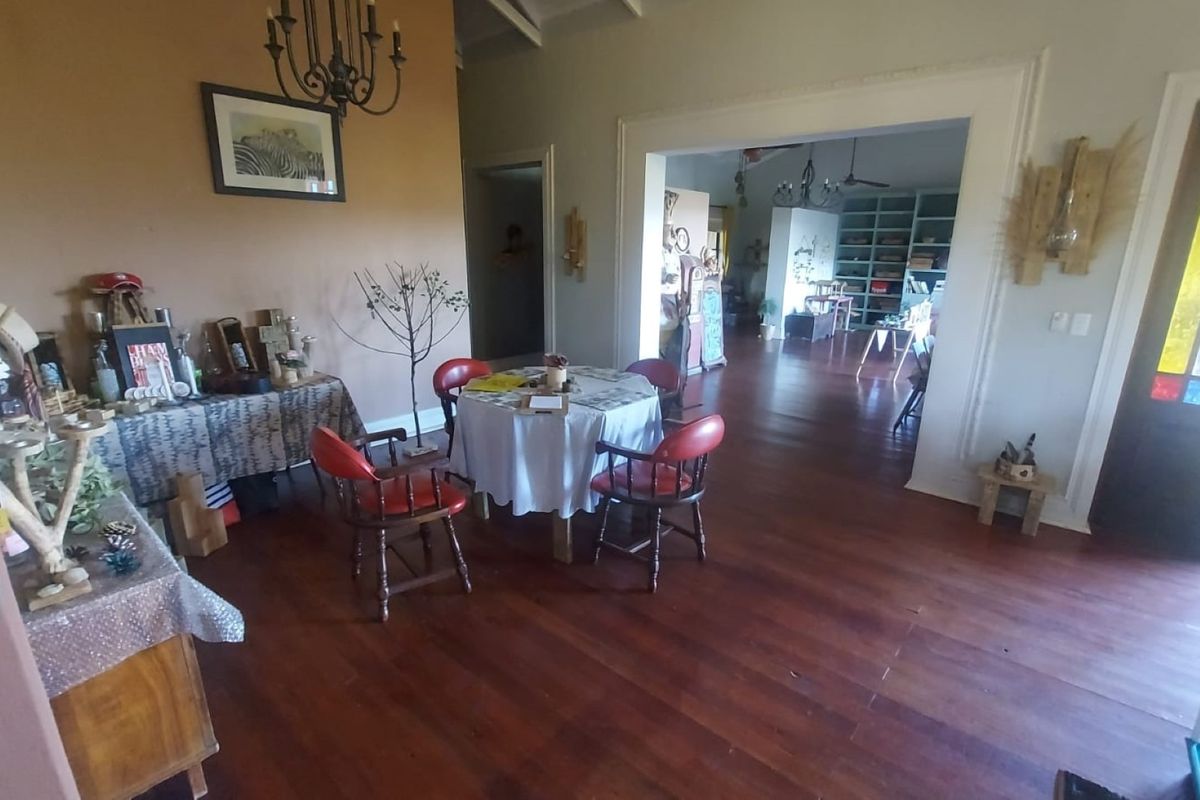 Spacious living area featuring warm hardwood flooring, a decorative archway, and a classic stained glass entrance door, offering a bright and inviting atmosphere.