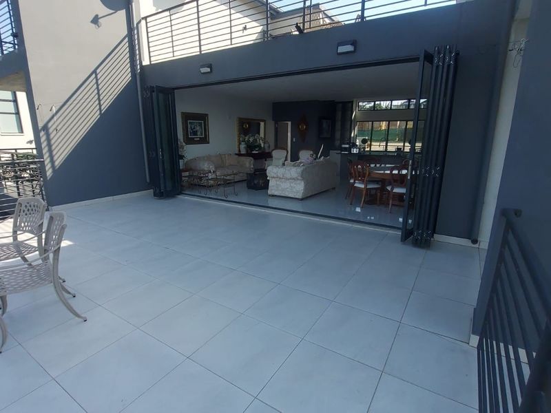 Spacious tiled balcony featuring modern bi-fold doors that provide seamless indoor-outdoor flow to the living area.