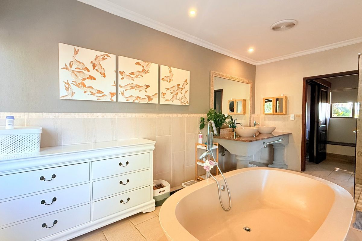 Spacious bathroom featuring a freestanding bathtub, double vanity with vessel sinks, stone countertops, and a separate walk-in shower area.
