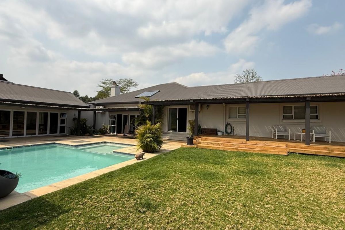 Spacious rear exterior featuring a swimming pool, timber decking, and a covered patio area, ideal for outdoor entertaining.