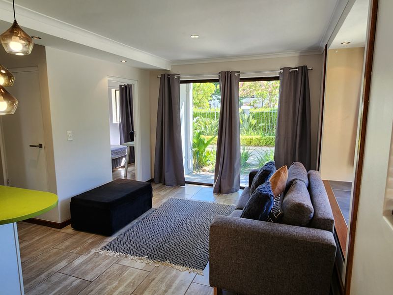 Open plan living area featuring a kitchen breakfast bar, tiled flooring, and sliding glass doors leading to an outdoor patio space.